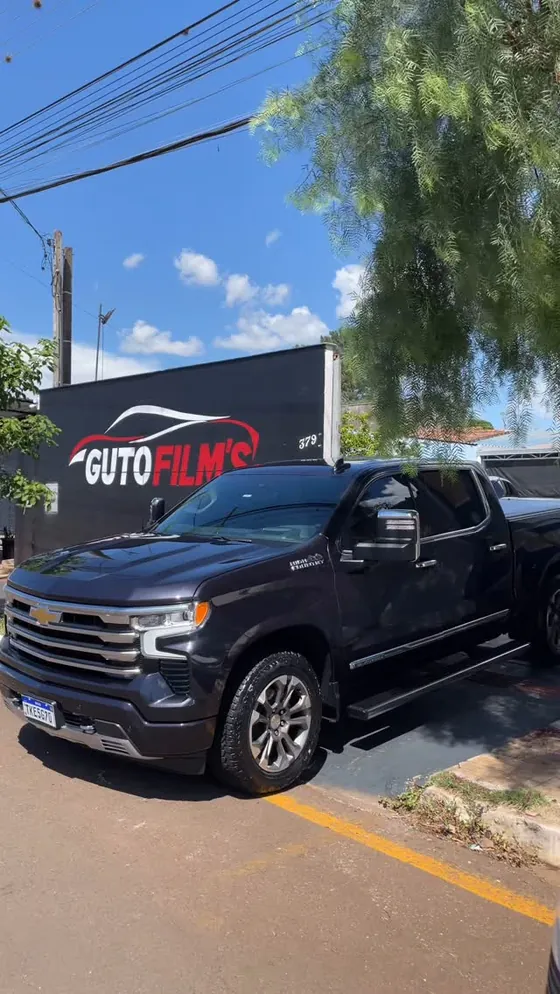 Chevrolet Silverado preta polida em frente à fachada da Guto Film's